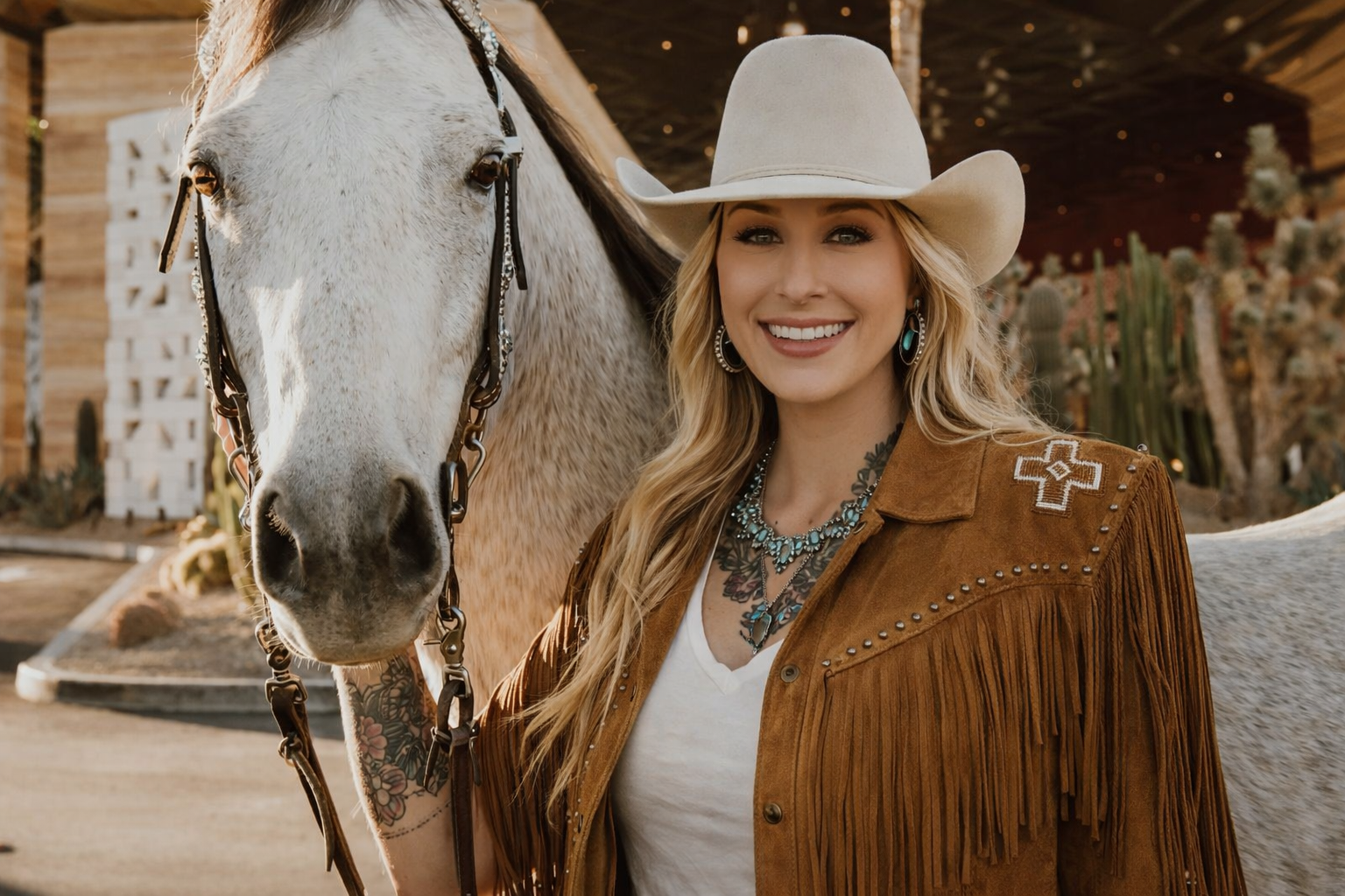 Woman in western fashion standing with a horse, representing the roots and inspiration behind Westynwild
